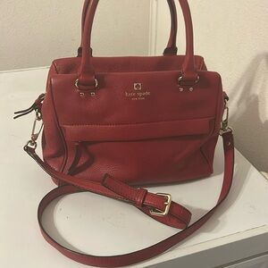 Kate Spade red leather 11” wide, 8.5” tall and 6” deep. Zippered pocket outside.